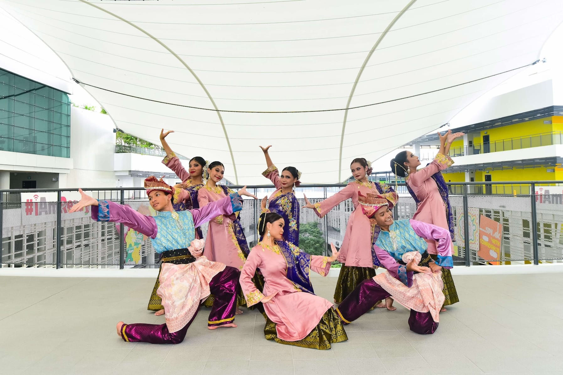 Group of dancers in traditional attire performing a choreographed routine outdoors.